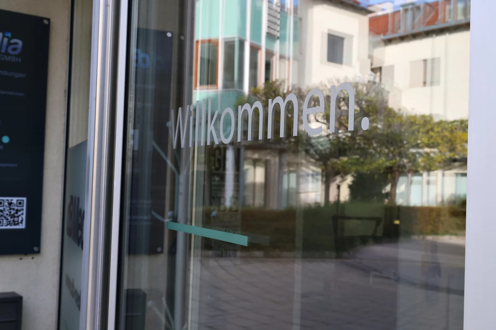 Glastür mit dem Schriftzug willkommen am Eingang des Büros in Baden